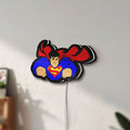 Unlit Superman S Shield LED lightbox mounted on a wall in daylight