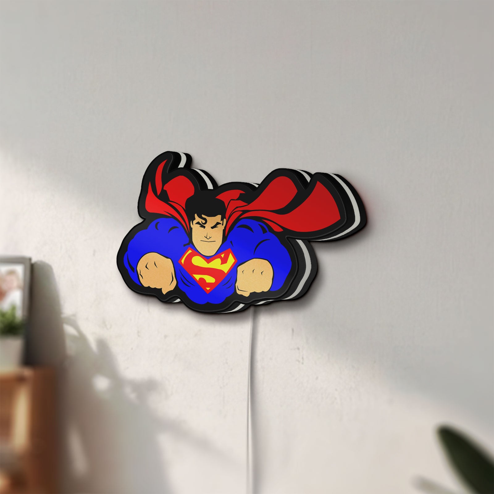 Unlit Superman S Shield LED lightbox mounted on a wall in daylight
