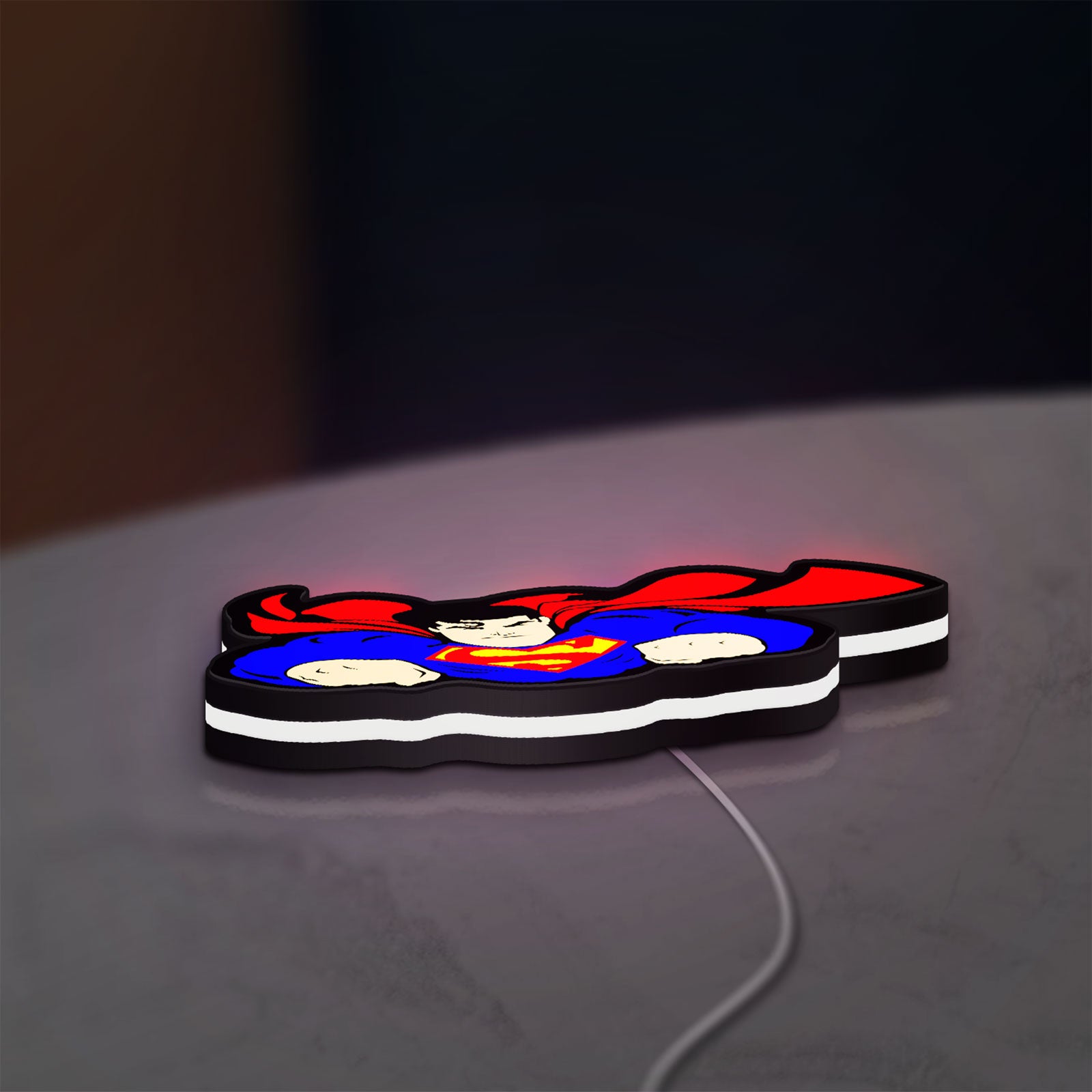 Superman S Shield LED lightbox lying flat on a desk with white glow
