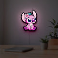 Pink Stitch LED lightbox hanging on a room wall with soft pink light