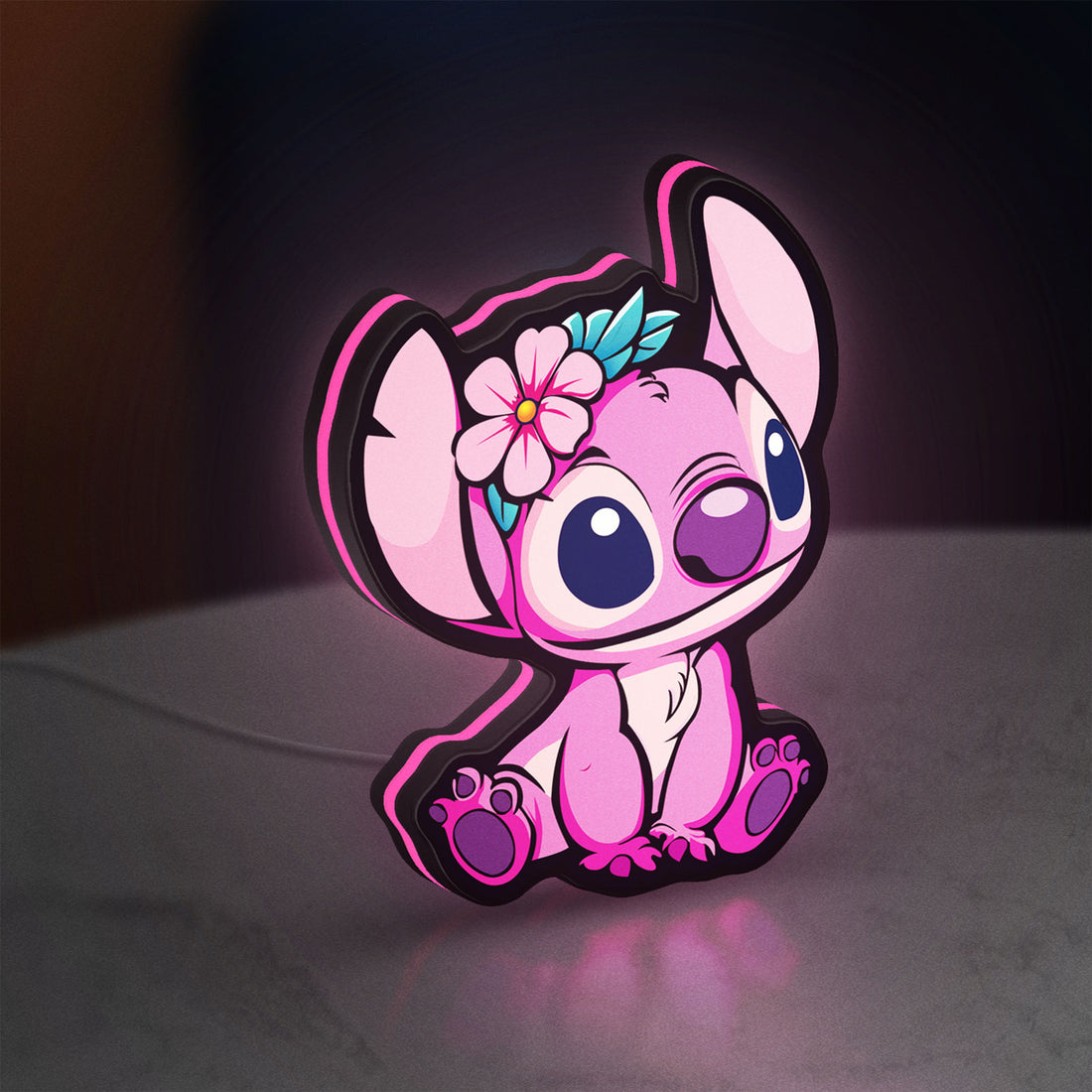 Pink Stitch LED lightbox hanging on a wall with pink glow