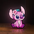 Front view of Pink Stitch LED lightbox sign glowing on a wooden desk