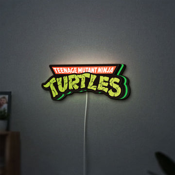 Turtles LED lightbox hanging on a wall with green glow