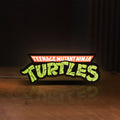 Front view of Turtles LED lightbox sign glowing on a wooden desk