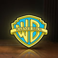 Front view of Warner Bros Shield LED lightbox sign glowing on a wooden desk