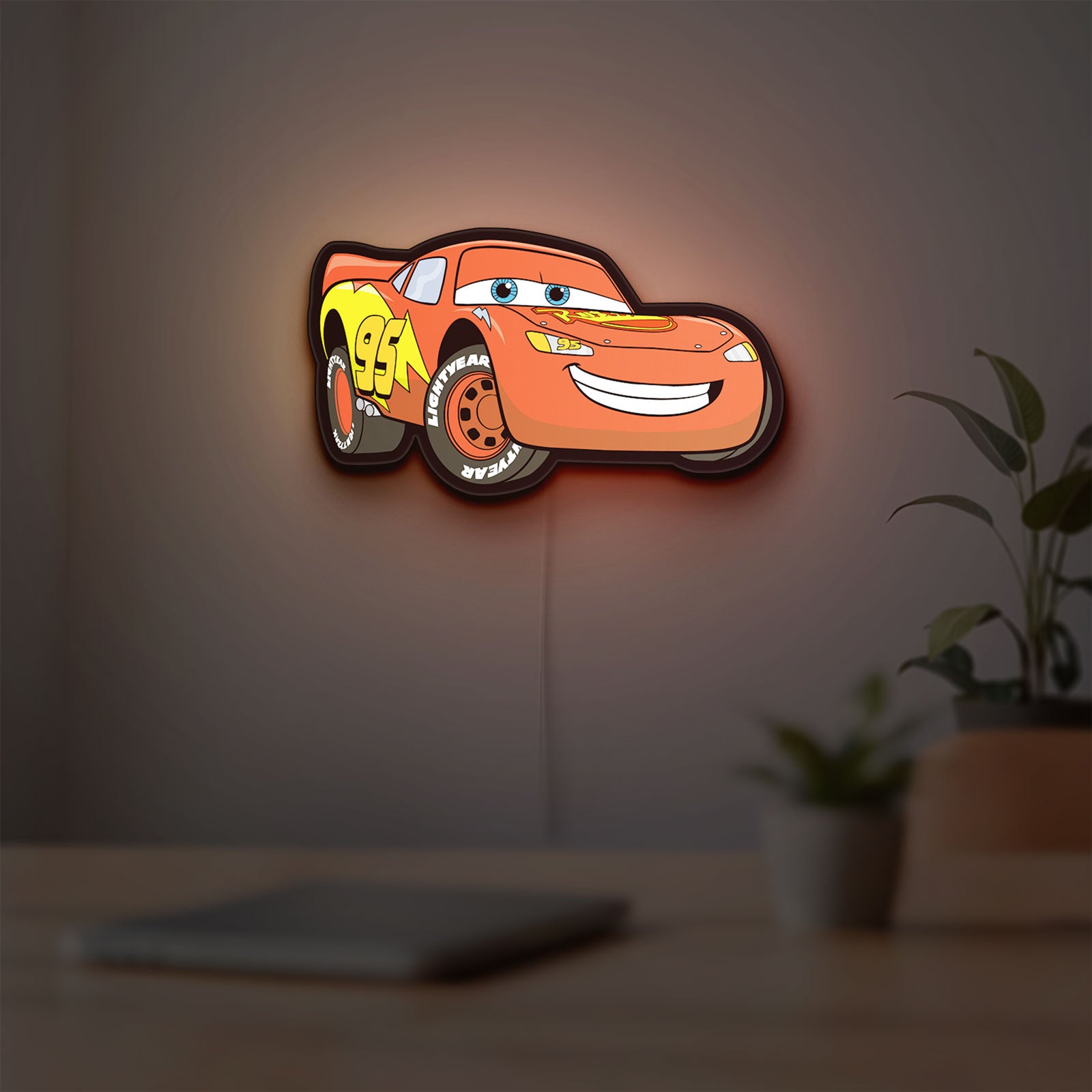 Lightning McQueen LED lightbox hanging on a room wall with soft orange light