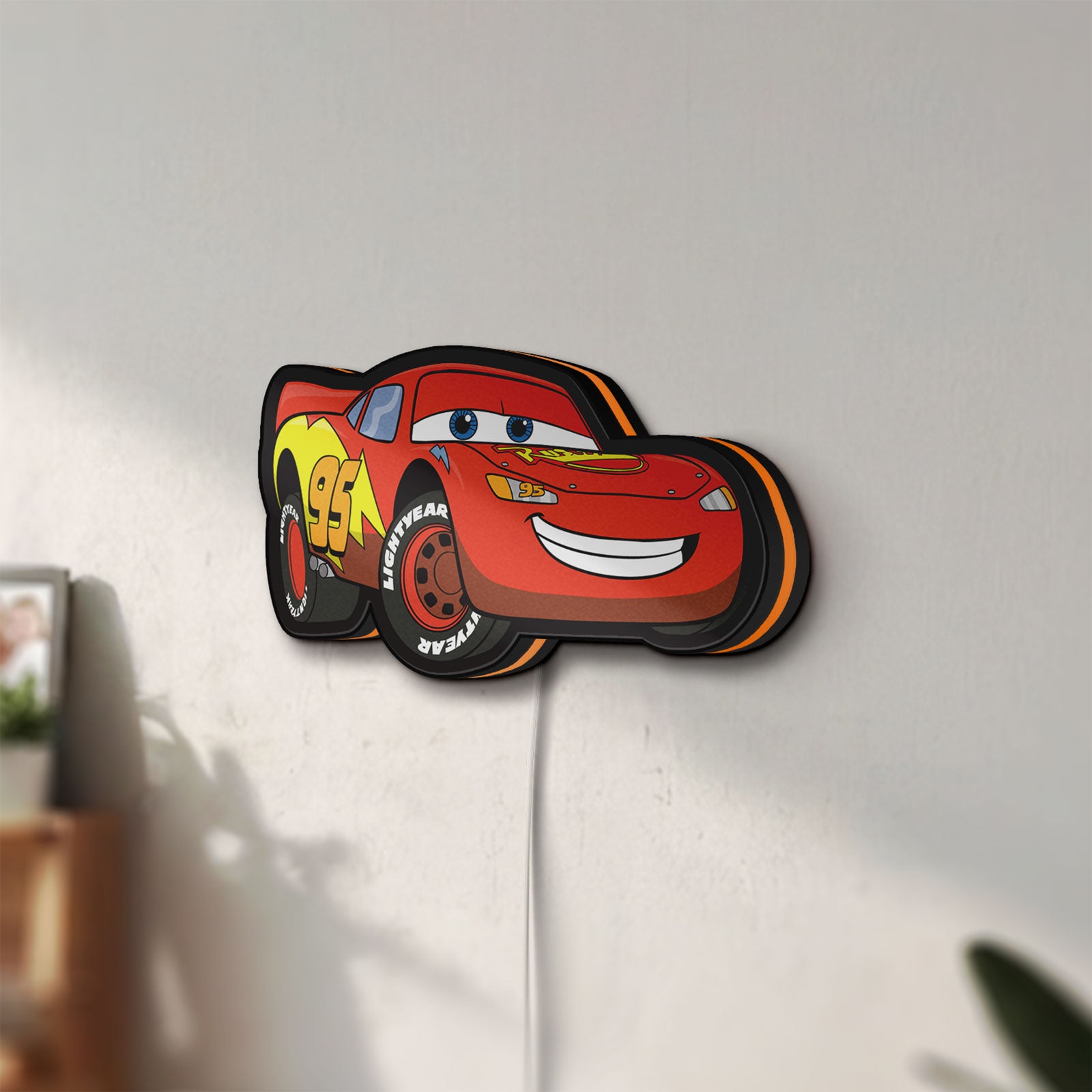 Unlit Lightning McQueen LED lightbox mounted on a wall in daylight