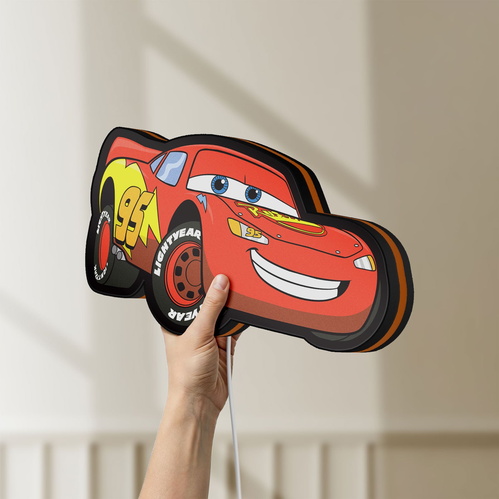 Unlit Lightning McQueen LED lightbox held by hand to show size and details