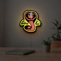 Cobra Kai LED lightbox hanging on a room wall with soft yellow light