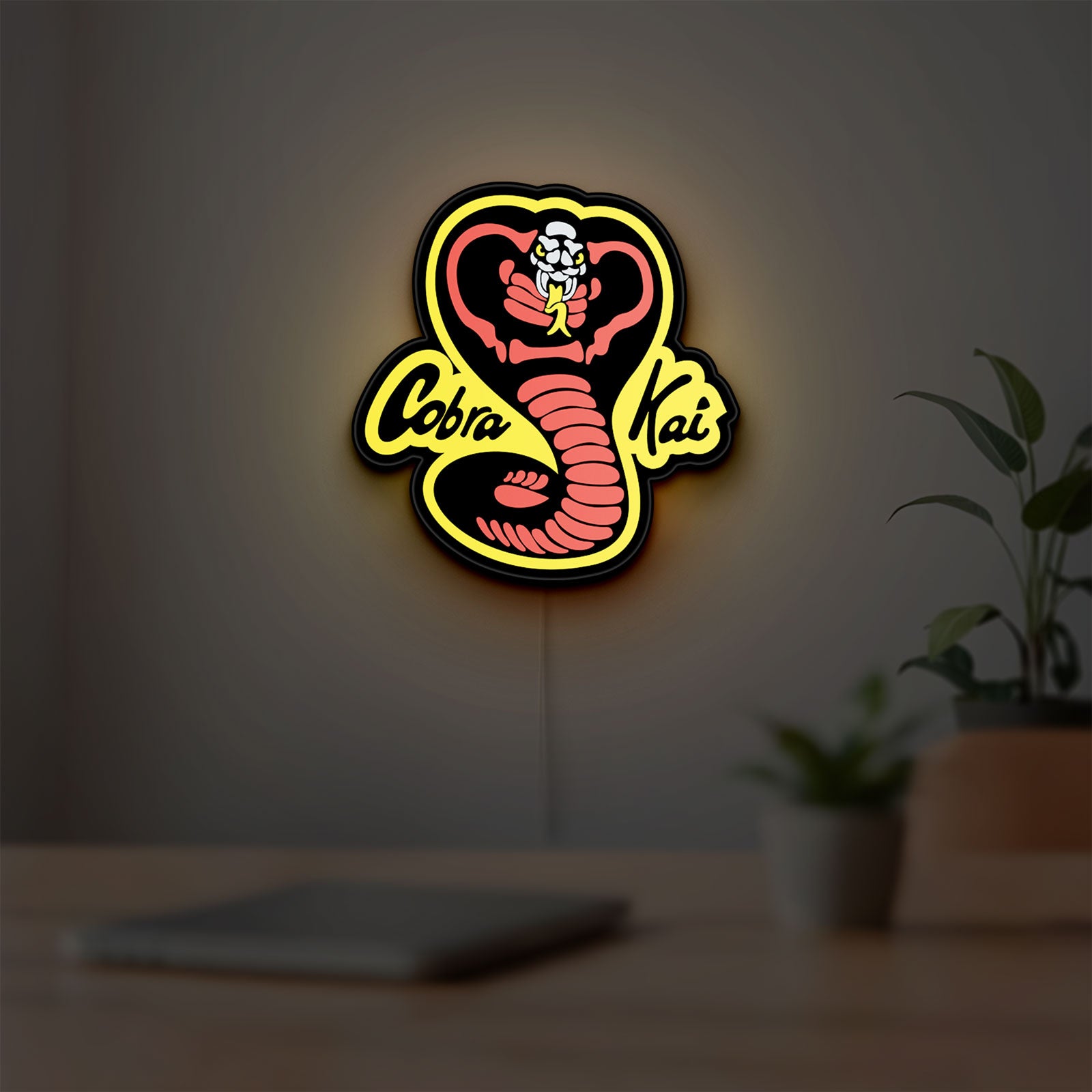 Cobra Kai LED lightbox hanging on a room wall with soft yellow light