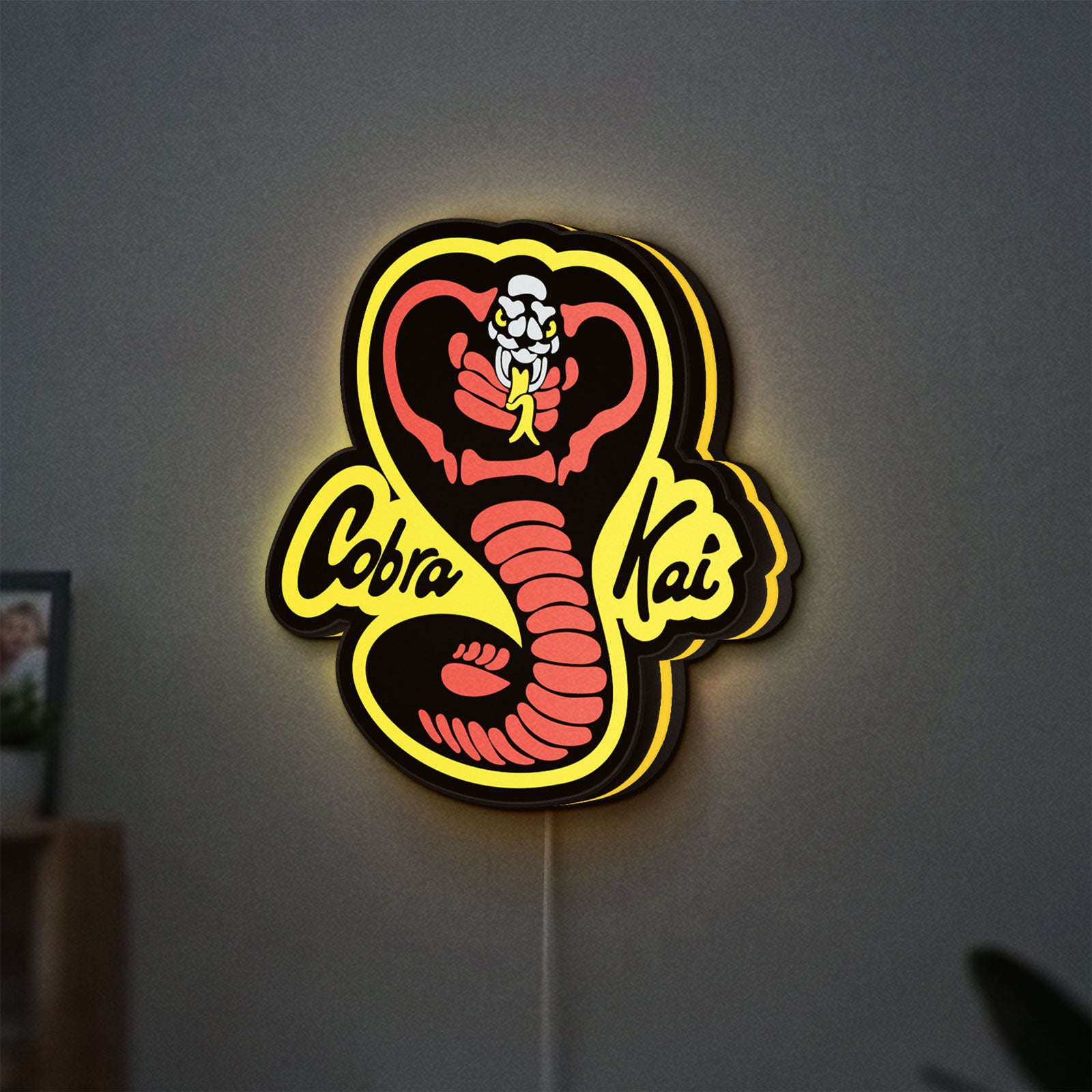 Cobra Kai LED lightbox hanging on a wall with yellow glow