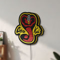 Unlit Cobra Kai LED lightbox mounted on a wall in daylight