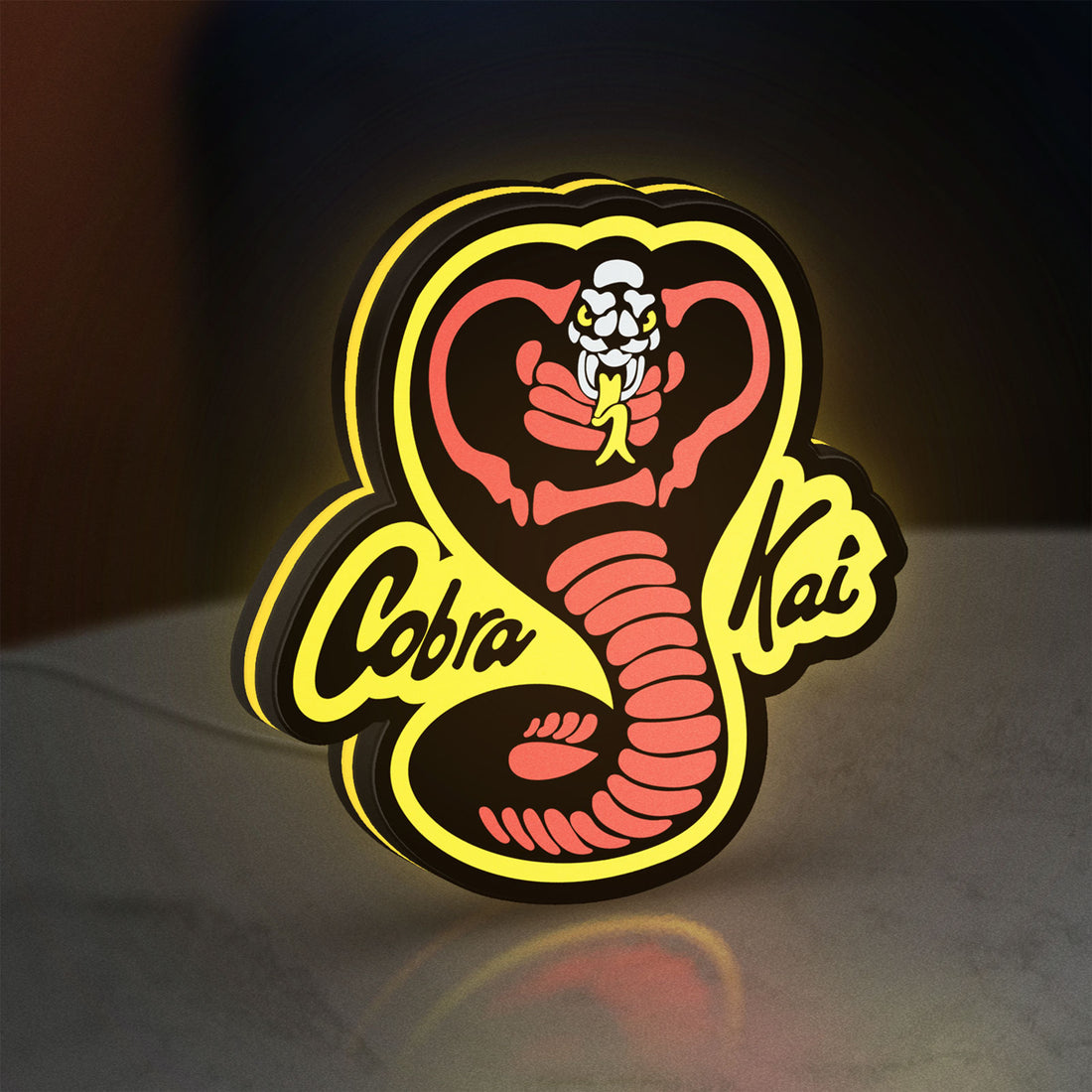 Cobra Kai LED lightbox hanging on a wall with yellow glow