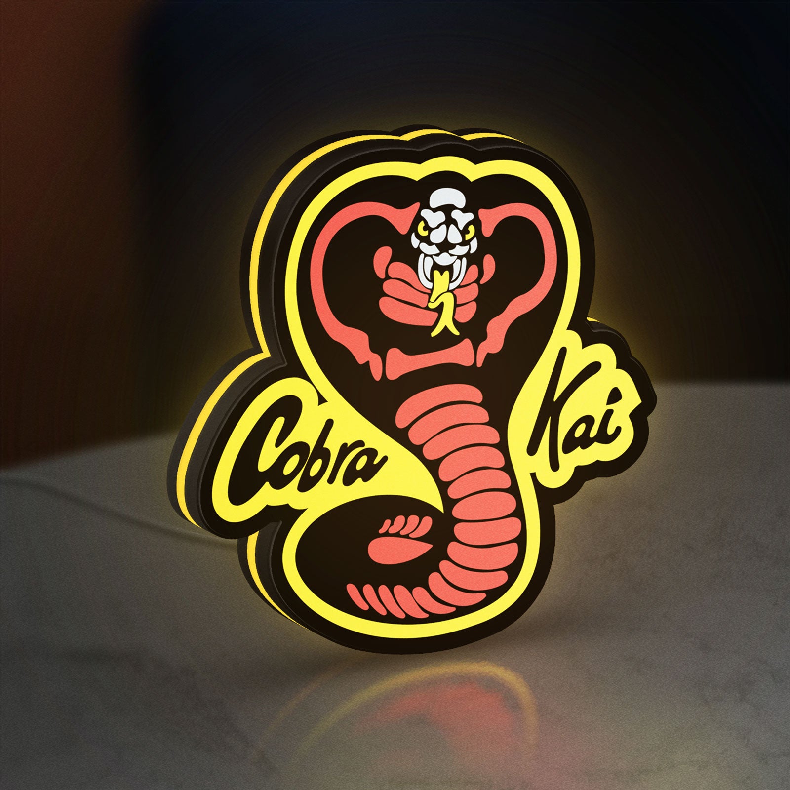 Cobra Kai LED lightbox standing on a desk from an angled side view with yellow glow