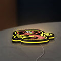 Cobra Kai LED lightbox lying flat on a desk with yellow glow