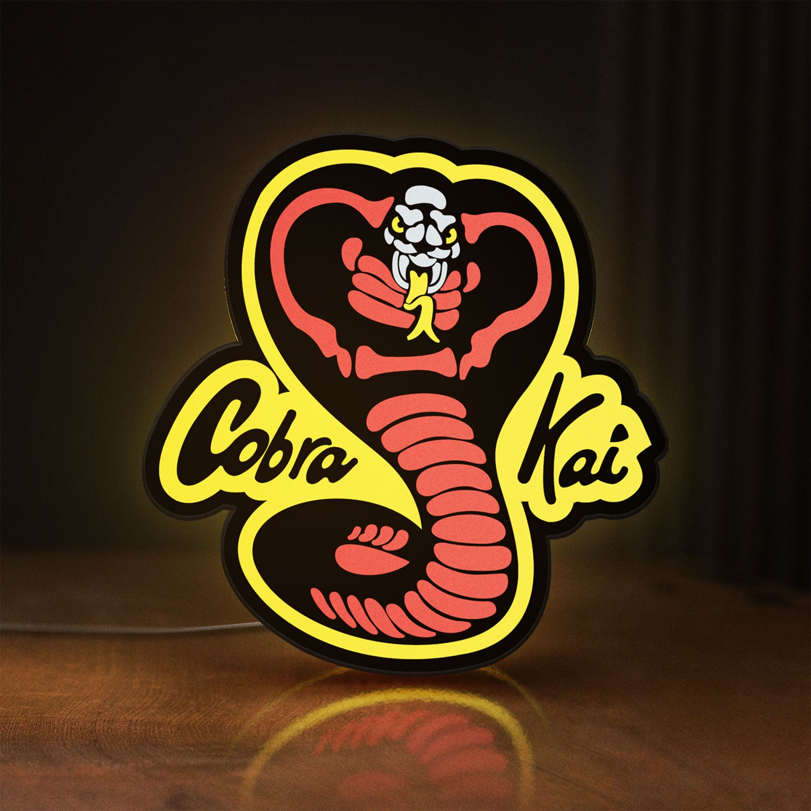 Front view of Cobra Kai LED lightbox sign glowing on a wooden desk
