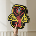 Unlit Cobra Kai LED lightbox held by hand to show size and details