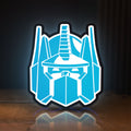 Front view of Optimus Prime LED lightbox sign glowing on a wooden desk