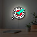Planet Express LED lightbox hanging on a room wall with soft white light