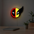 Deadpool & Wolverine Icon LED lightbox hanging on a room wall with soft yellow light