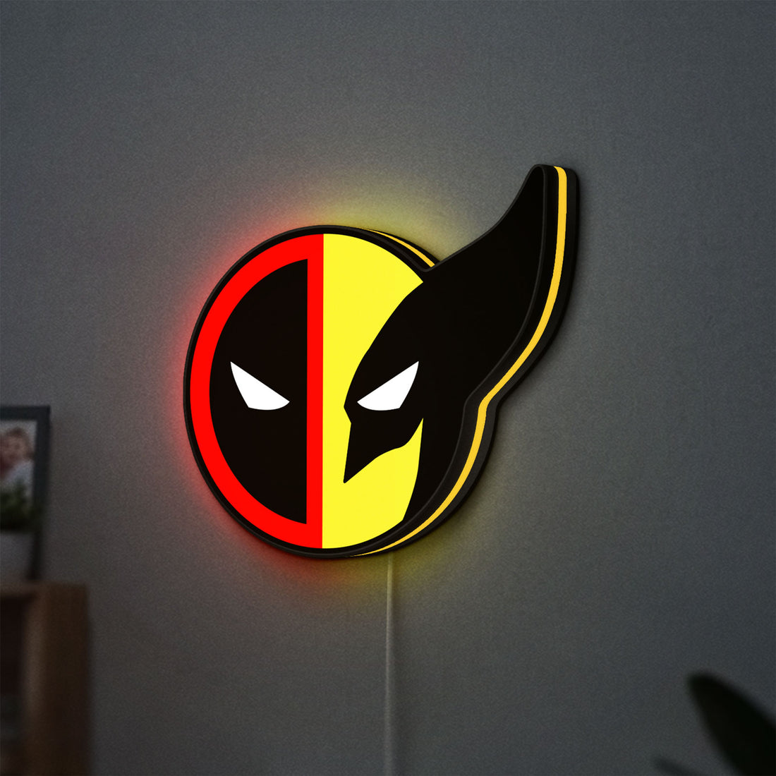 Deadpool & Wolverine Icon LED lightbox hanging on a wall with yellow glow