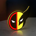 Deadpool & Wolverine Icon LED lightbox standing on a desk from an angled side view with yellow glow