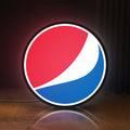 Front view of Pepsi LED lightbox sign glowing on a wooden desk