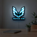 Trans Am LED lightbox hanging on a room wall with soft blue light