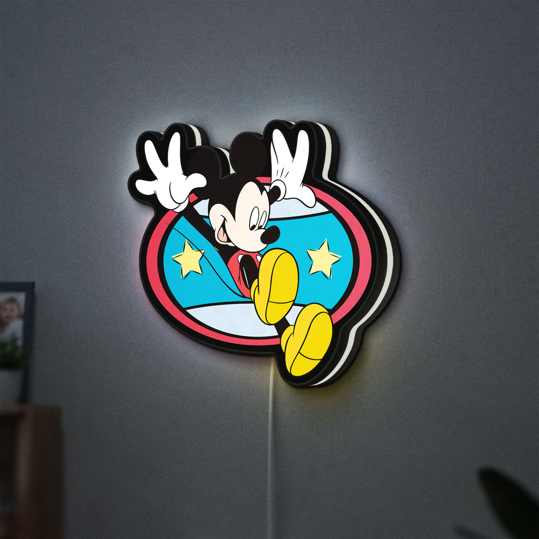 Mickey Mouse LED lightbox hanging on a wall with white glow