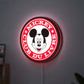 Mickey Club Du Livre LED lightbox hanging on a wall with red glow
