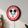 Unlit Mickey Club Du Livre LED lightbox mounted on a wall in daylight