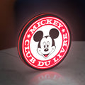 Mickey Club Du Livre LED lightbox standing on a desk from an angled side view with red glow