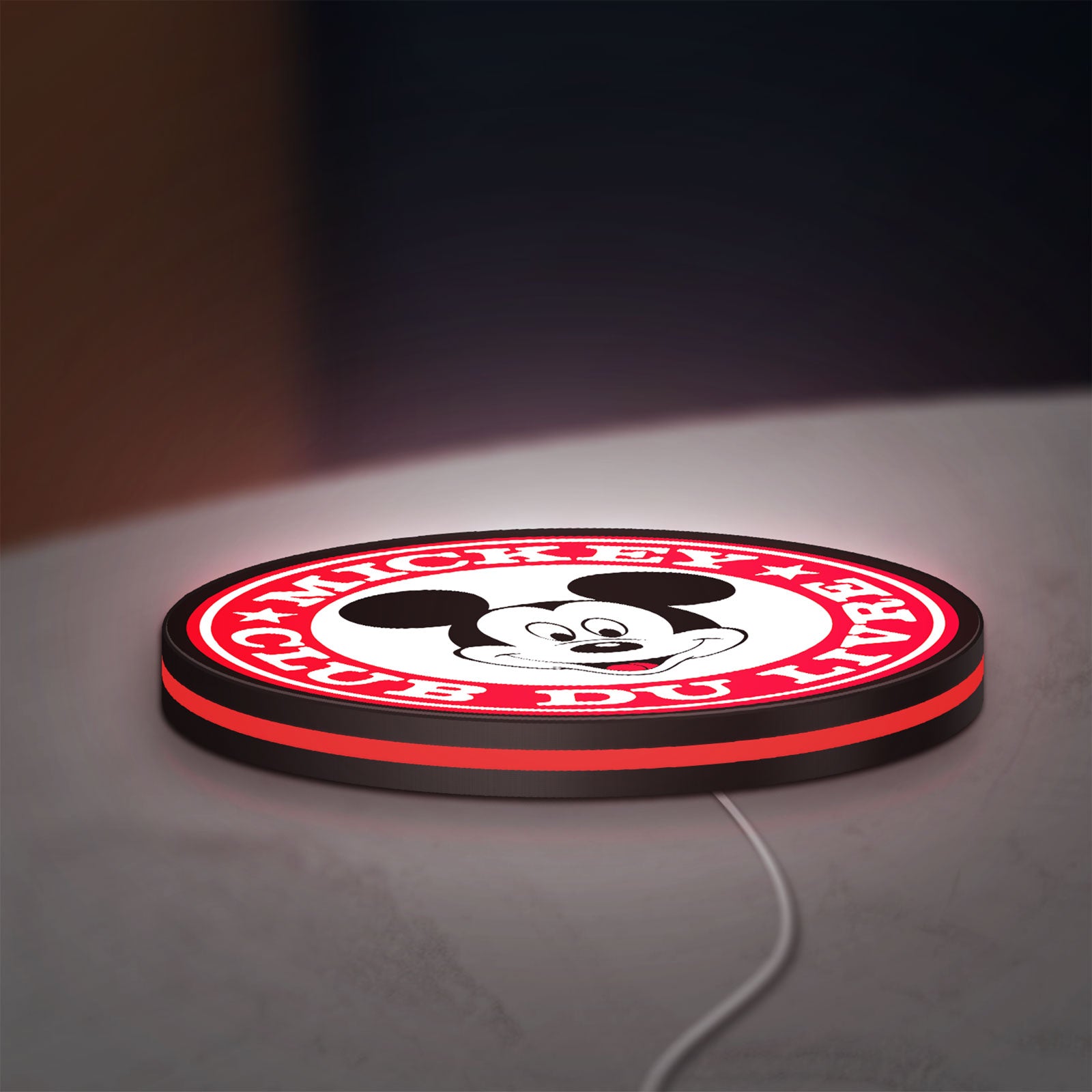 Mickey Club Du Livre LED lightbox lying flat on a desk with red glow