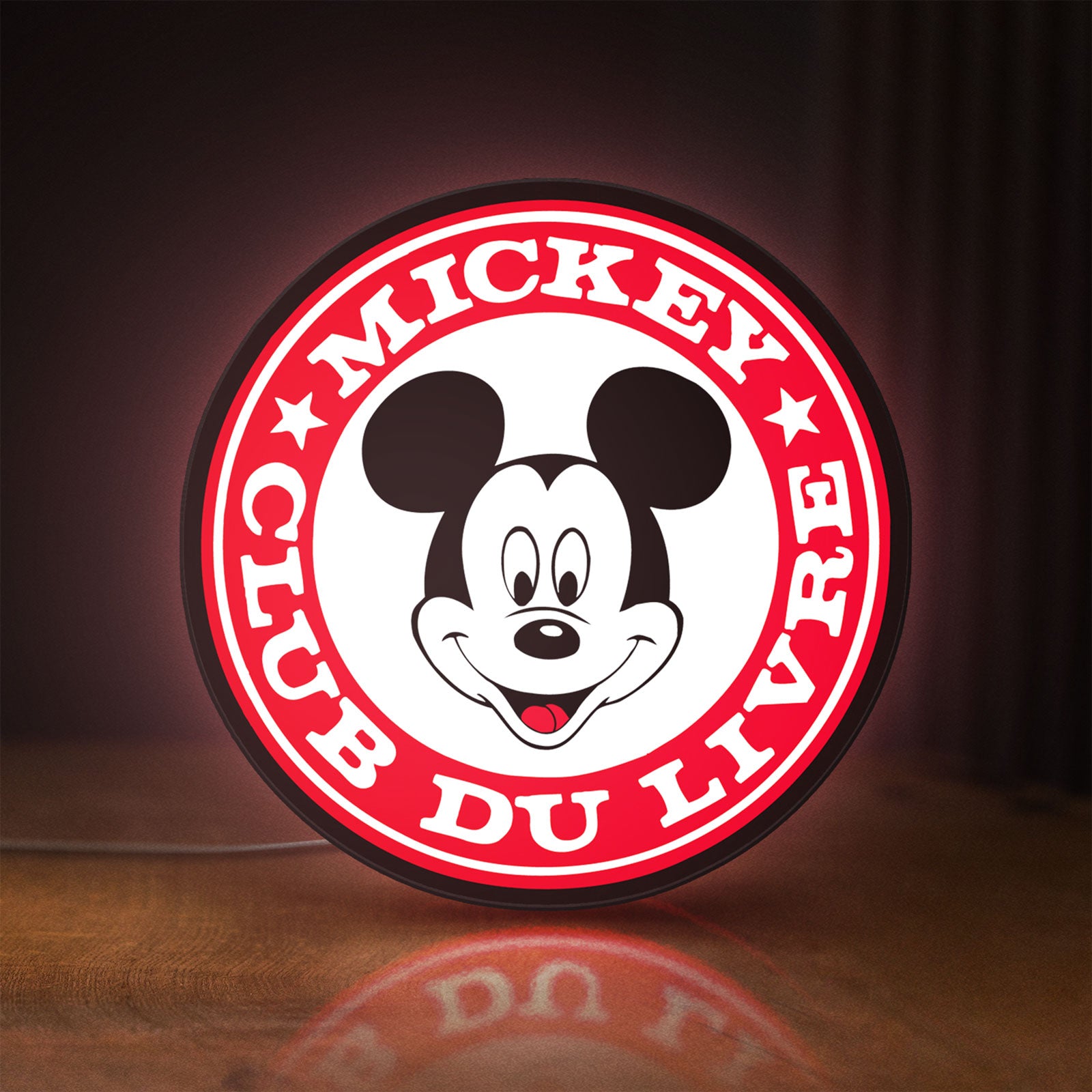 Front view of Mickey Club Du Livre LED lightbox sign glowing on a wooden desk