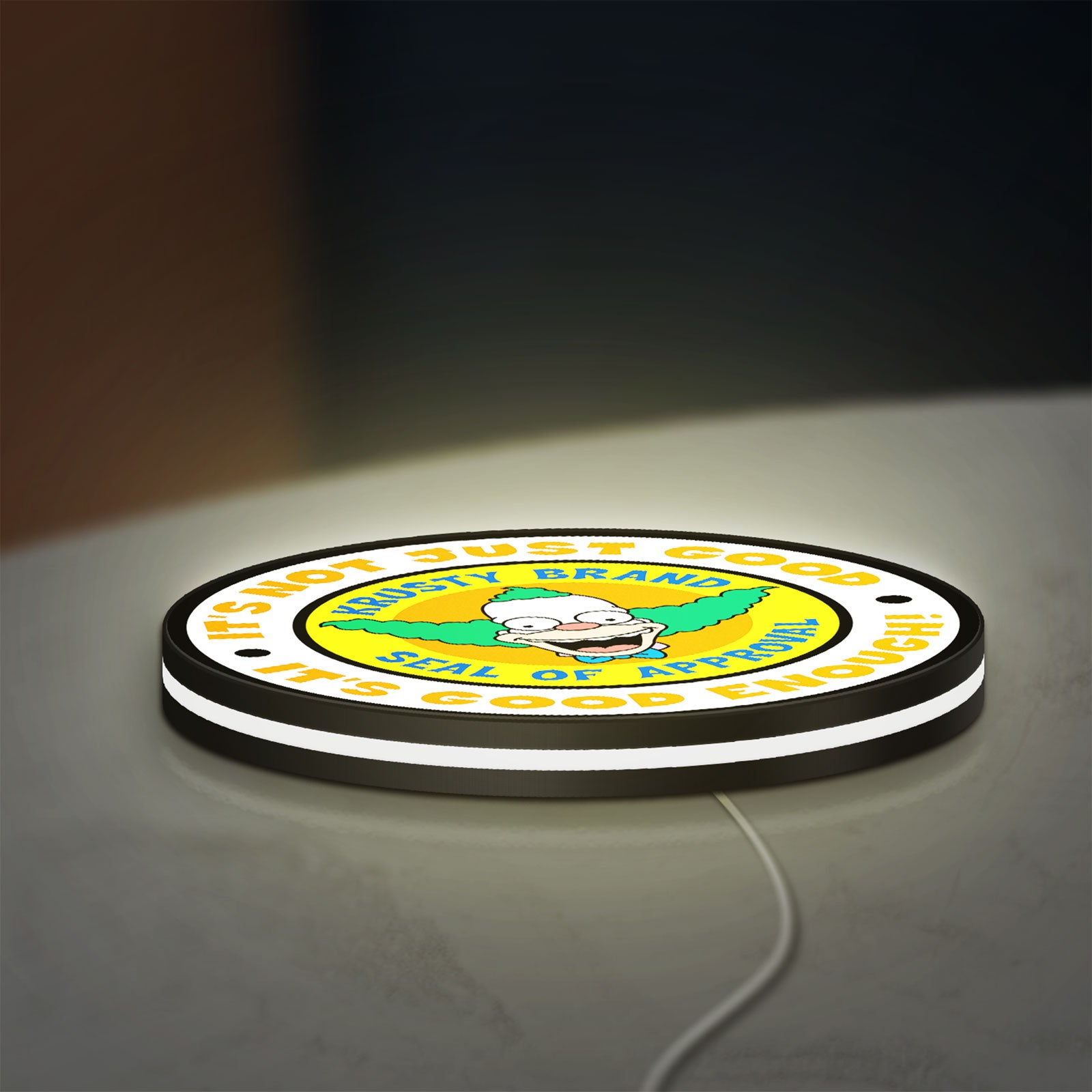 The Simpsons LED lightbox lying flat on a desk with white glow