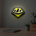 Troy Lee Designs LED lightbox hanging on a room wall with soft yellow light
