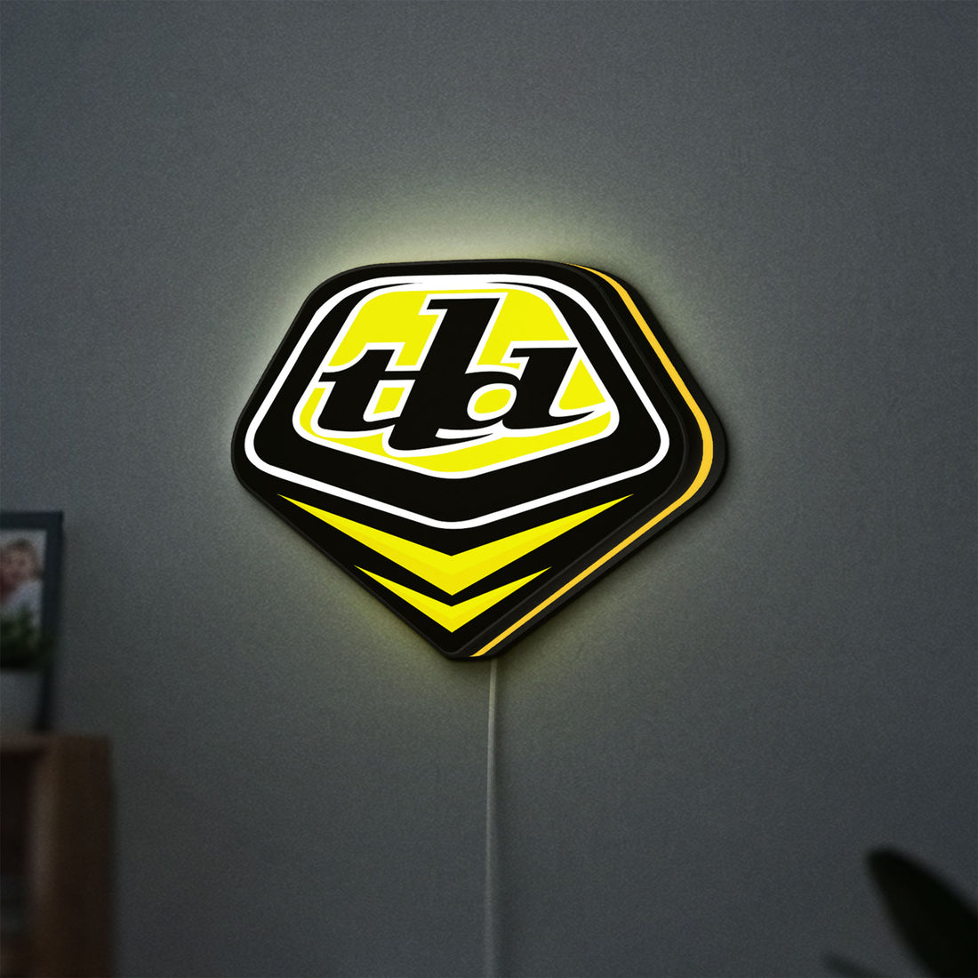 Troy Lee Designs LED lightbox hanging on a wall with yellow glow