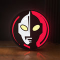 Front view of Ultraman LED lightbox sign glowing on a wooden desk