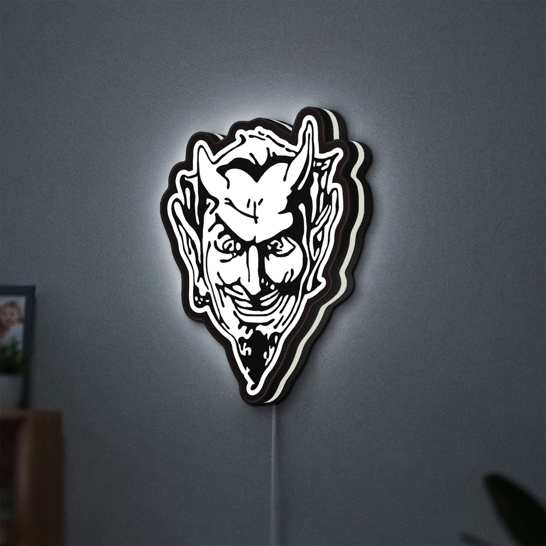 Devil Head LED lightbox hanging on a wall with white glow