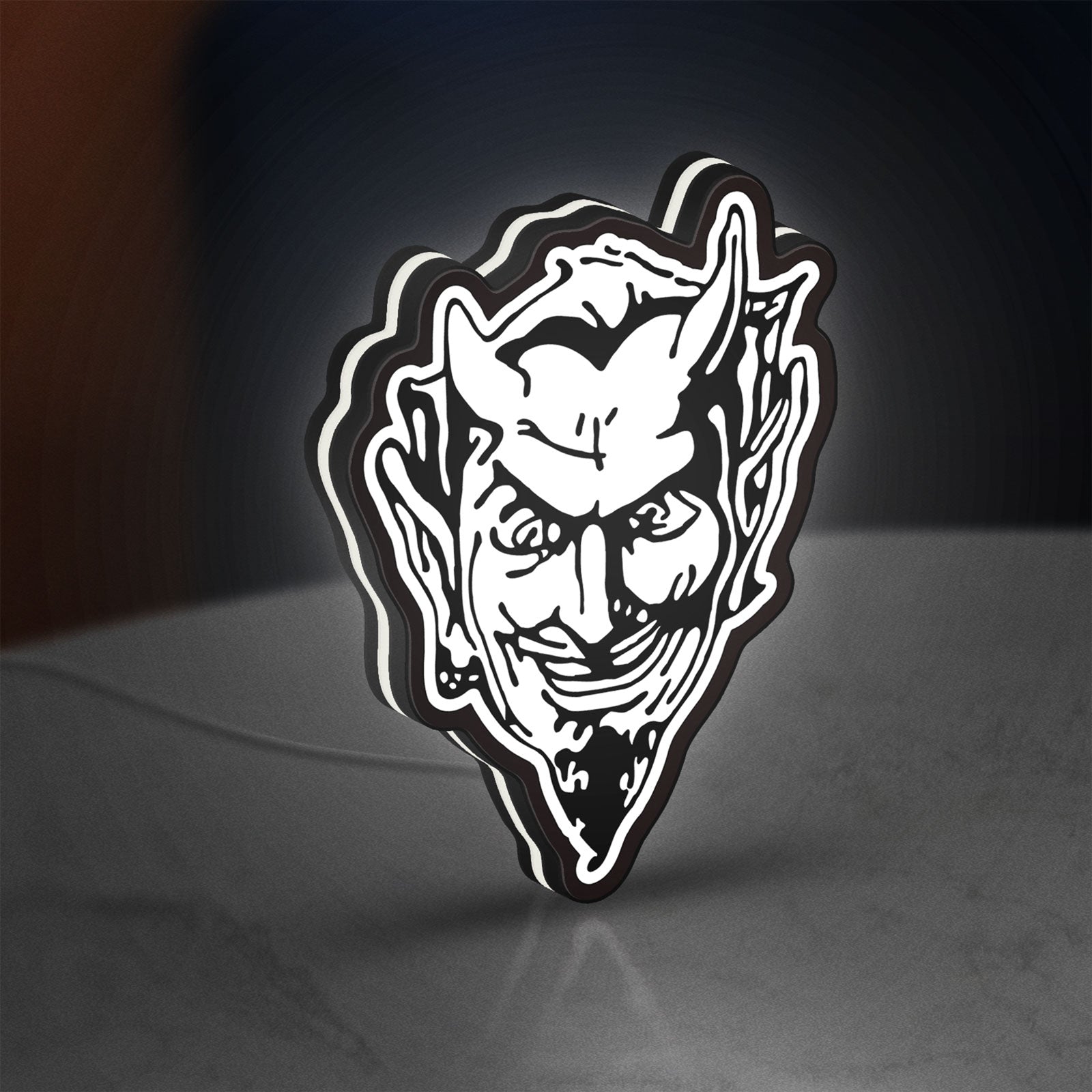 Devil Head LED lightbox standing on a desk from an angled side view with white glow