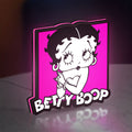 Betty Boop LED lightbox standing on a desk from an angled side view with pink glow