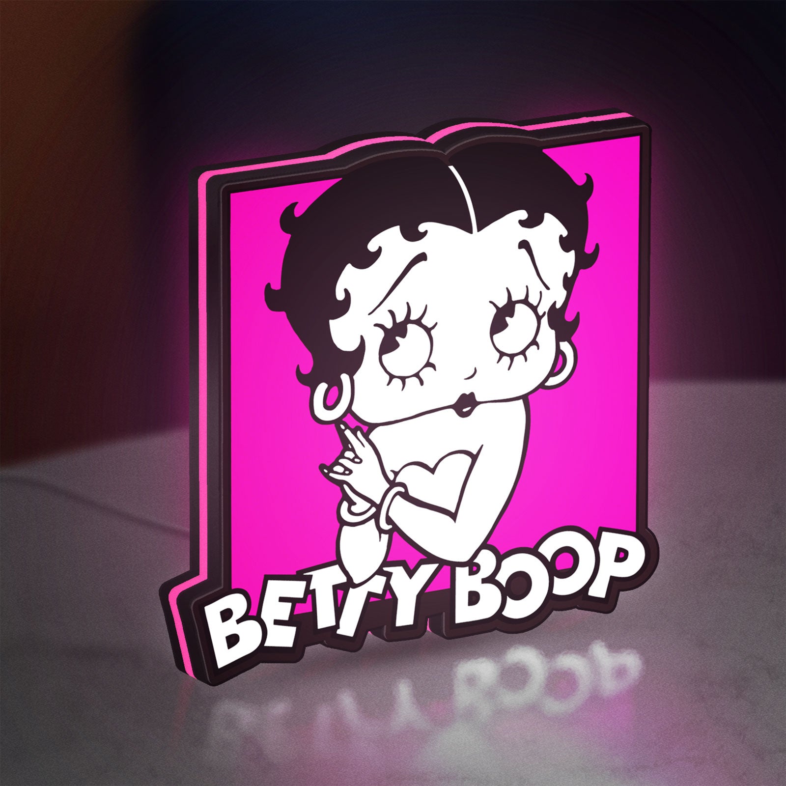 Betty Boop LED lightbox standing on a desk from an angled side view with pink glow