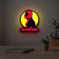 Deadpool LED lightbox hanging on a room wall with soft yellow light