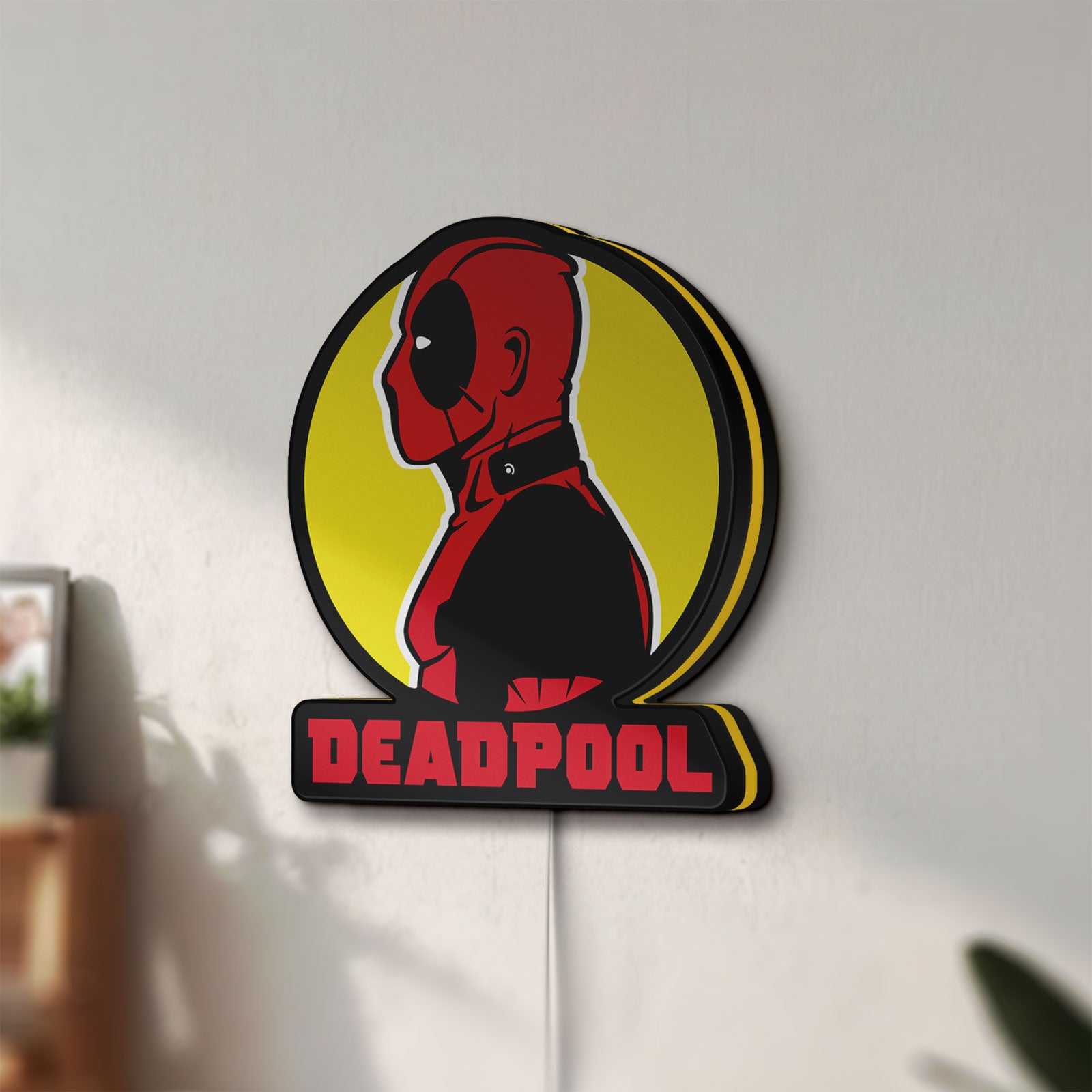 Unlit Deadpool LED lightbox mounted on a wall in daylight