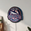 Unlit Tiburones De La Guaira LED lightbox mounted on a wall in daylight