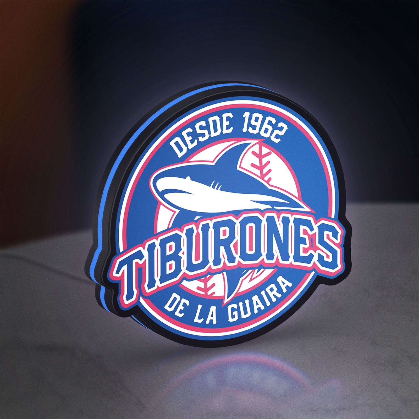 Tiburones De La Guaira LED lightbox standing on a desk from an angled side view with blue glow