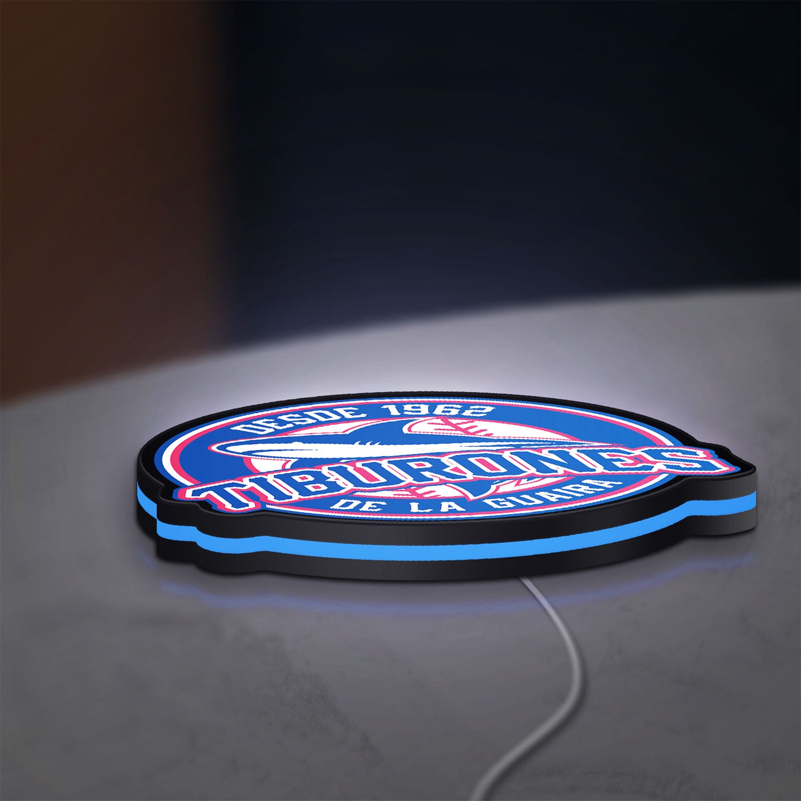 Tiburones De La Guaira LED lightbox lying flat on a desk with blue glow