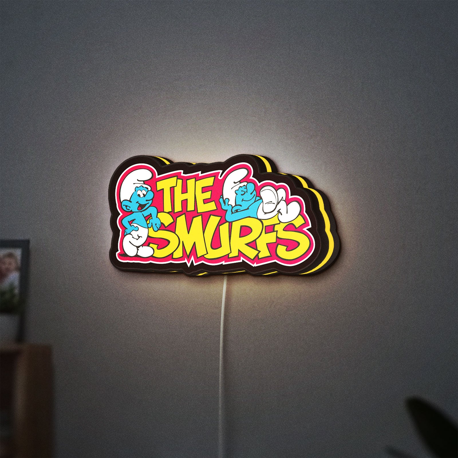 Smurfs LED lightbox hanging on a wall with yellow glow