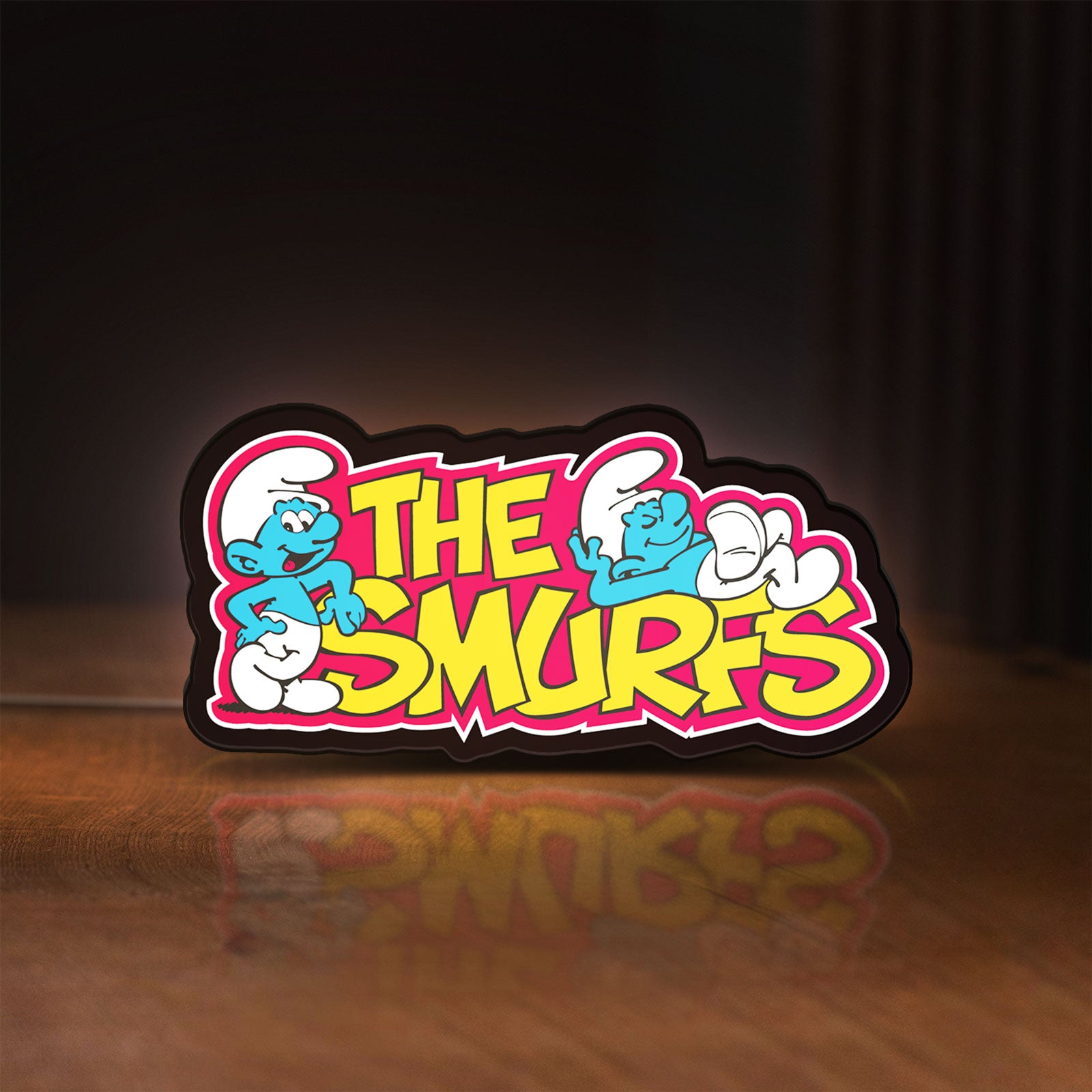 Front view of Smurfs LED lightbox sign glowing on a wooden desk