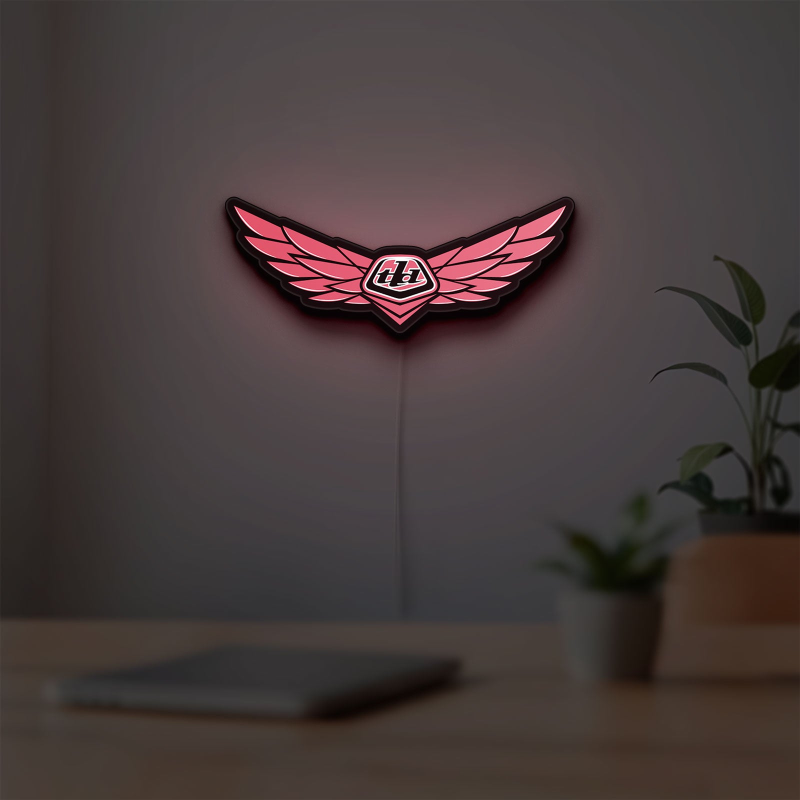 Troy Lee Designs LED lightbox hanging on a room wall with soft red light